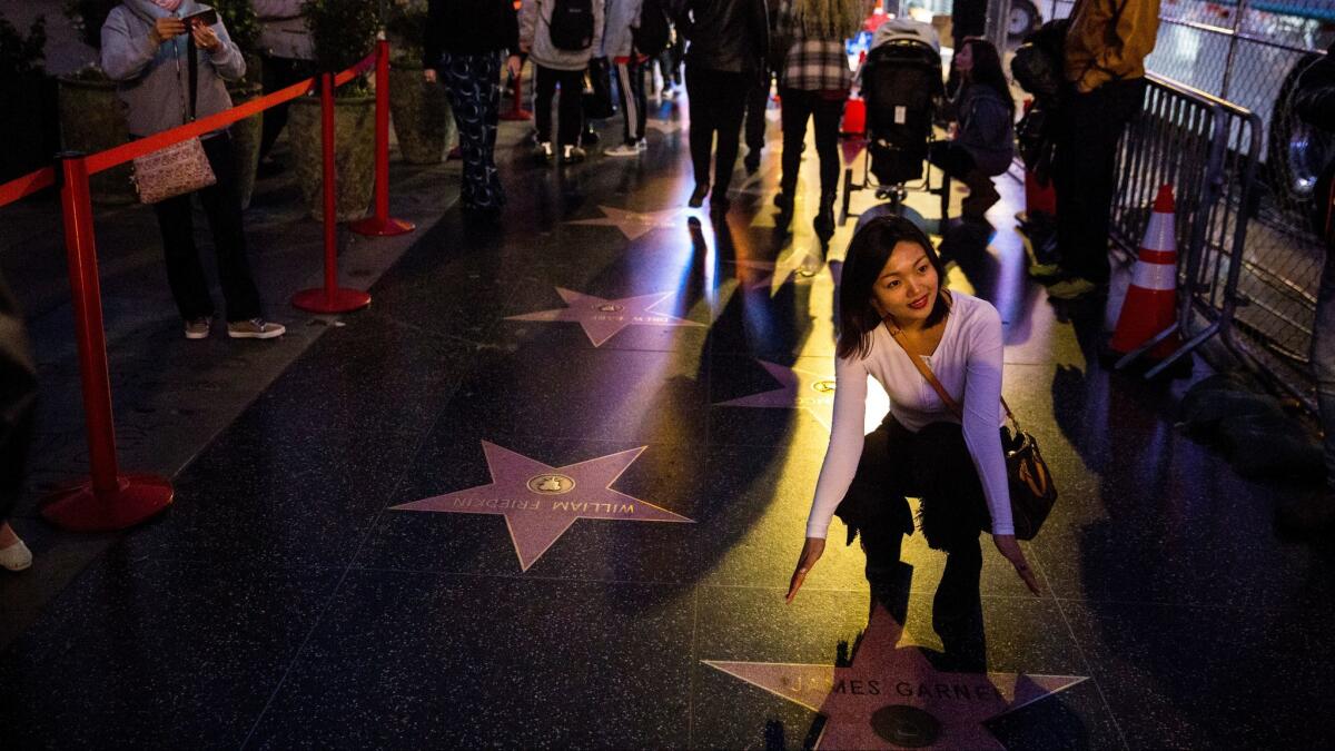 Reaching for the stars on the Walk of Fame before the TCL Chinese Theater on Hollywood Boulevard.