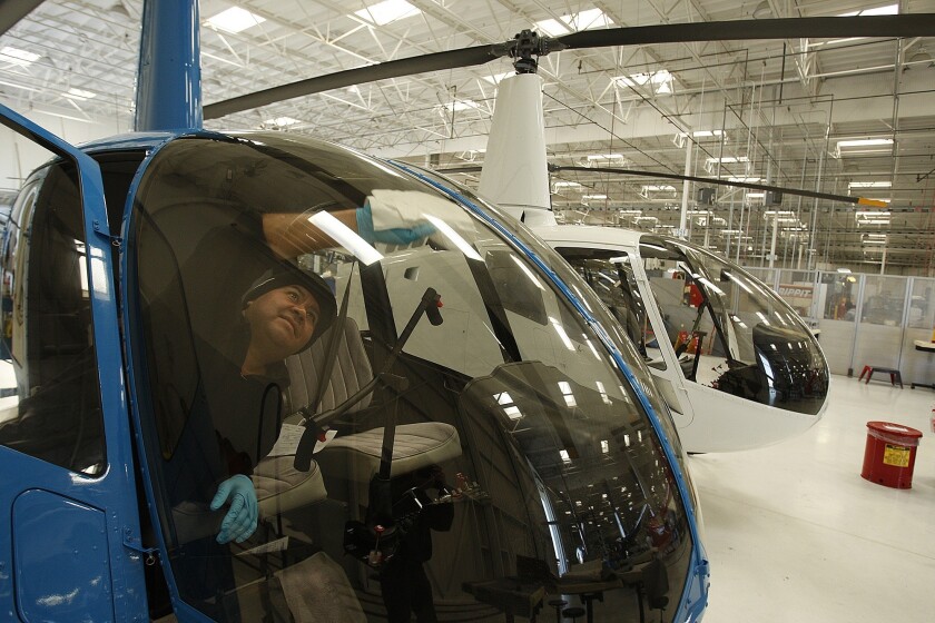 A technician wipes the window of an R44 helicopter at Robinson Helicopter Co.'s factory in Torrance.