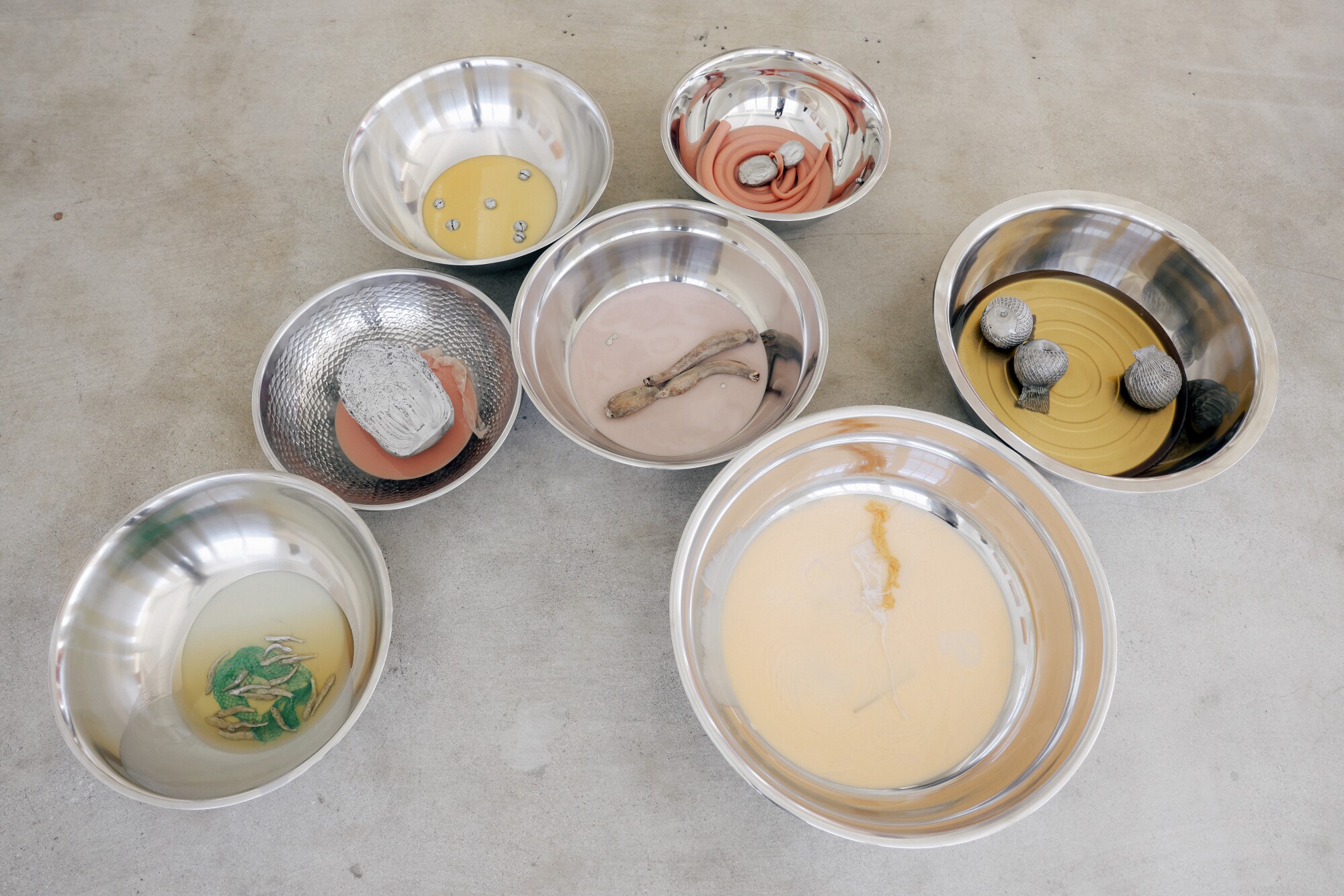 A cluster of bowls on the floor, in varying sizes.