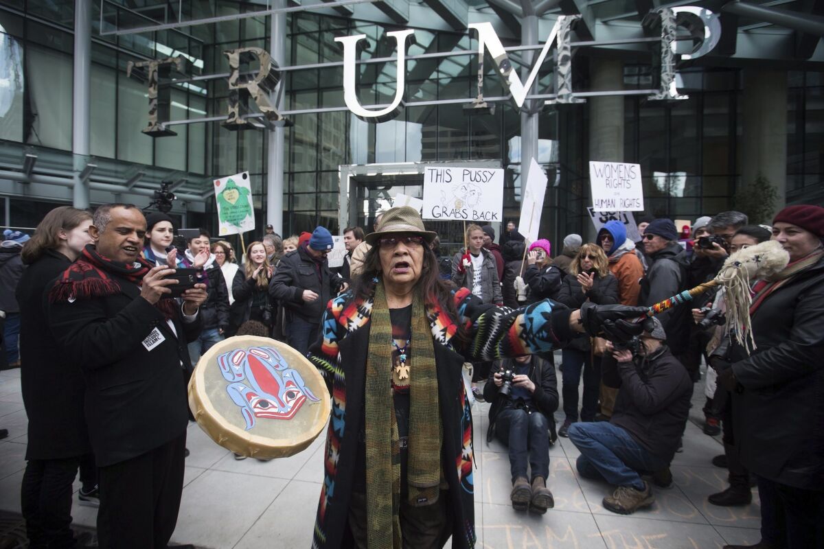 Viviane Sandy of Williams Lake, Canada, plays a drum outside the official opening of the Trump International Hotel & Tower Vancouver on Feb. 28, 2017.