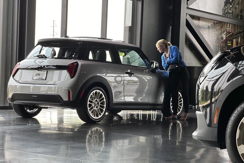 ARCHIVO – Una posible compradora mira un auto Cooper S 2025 exhibido en una concesionaria de Mini el 22 de julio de 2024, en Highlands Ranch, Colorado. (AP Foto/David Zalubowski, Archivo)