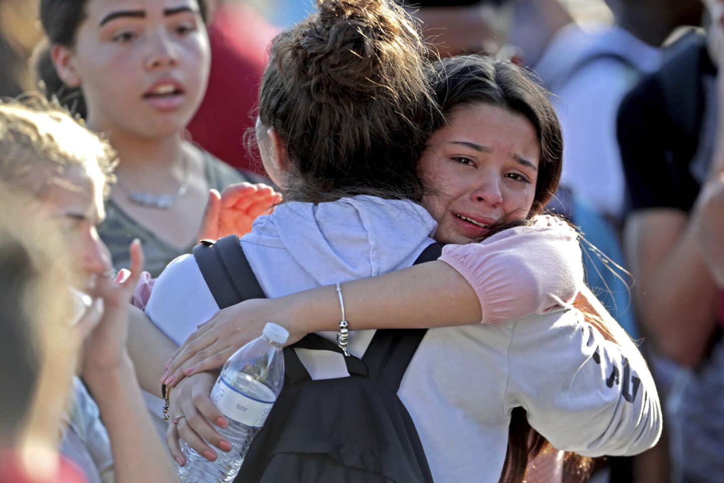 Students released from a lockdown embrace after the shooting at Marjory Stoneman Douglas High School in Parkland, Fla.