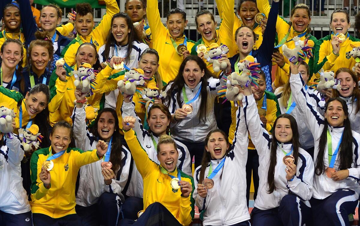 The Brazilian (yellow) and Argentinian teams celebrate their gold and silver respectively following the Women's Gold Medal Handball match Brazil vs. Argentina during the 2015 Pan American Games in Toronto, Canada, July 24, 2015. Brazil won 25-20. AFP PHOTO Eva HAMBACHEVA HAMBACH/AFP/Getty Images ** OUTS - ELSENT, FPG - OUTS * NM, PH, VA if sourced by CT, LA or MoD **