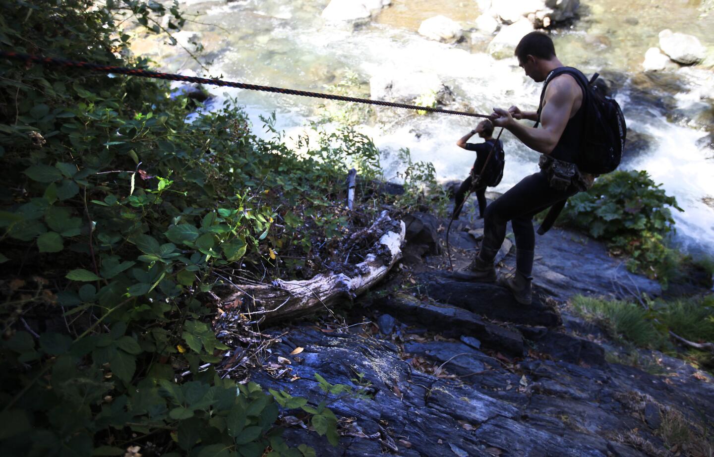 Justin Fairchild, left, and Carson Odegard use ropes to lower themselves into a steep canyon during the state Fish and Wildlife Department's weekly survey of spring-run Chinook salmon in Butte Creek near Chico.