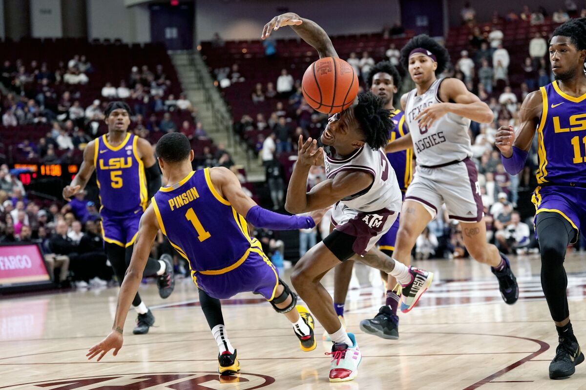Texas A&M guard Quenton Jackson (3) lis fouled by LSU guard Xavier Pinson (1) on a fast break during the second half of an NCAA college basketball game Tuesday, Feb. 8, 2022, in College Station, Texas. (AP Photo/Sam Craft)