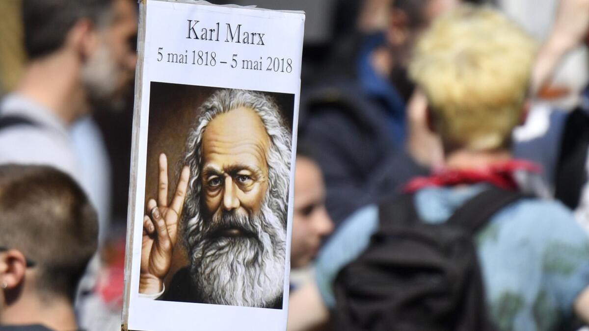 A protester in Paris carries a placard showing Karl Marx on May 5.