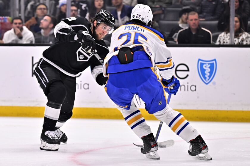 Los Angeles Kings right wing Adrian Kempe, left, shoots to score against Buffalo Sabres defenseman Owen Power during the second period of an NHL hockey game in Los Angeles, Monday, Feb. 13, 2023. (AP Photo/Alex Gallardo)