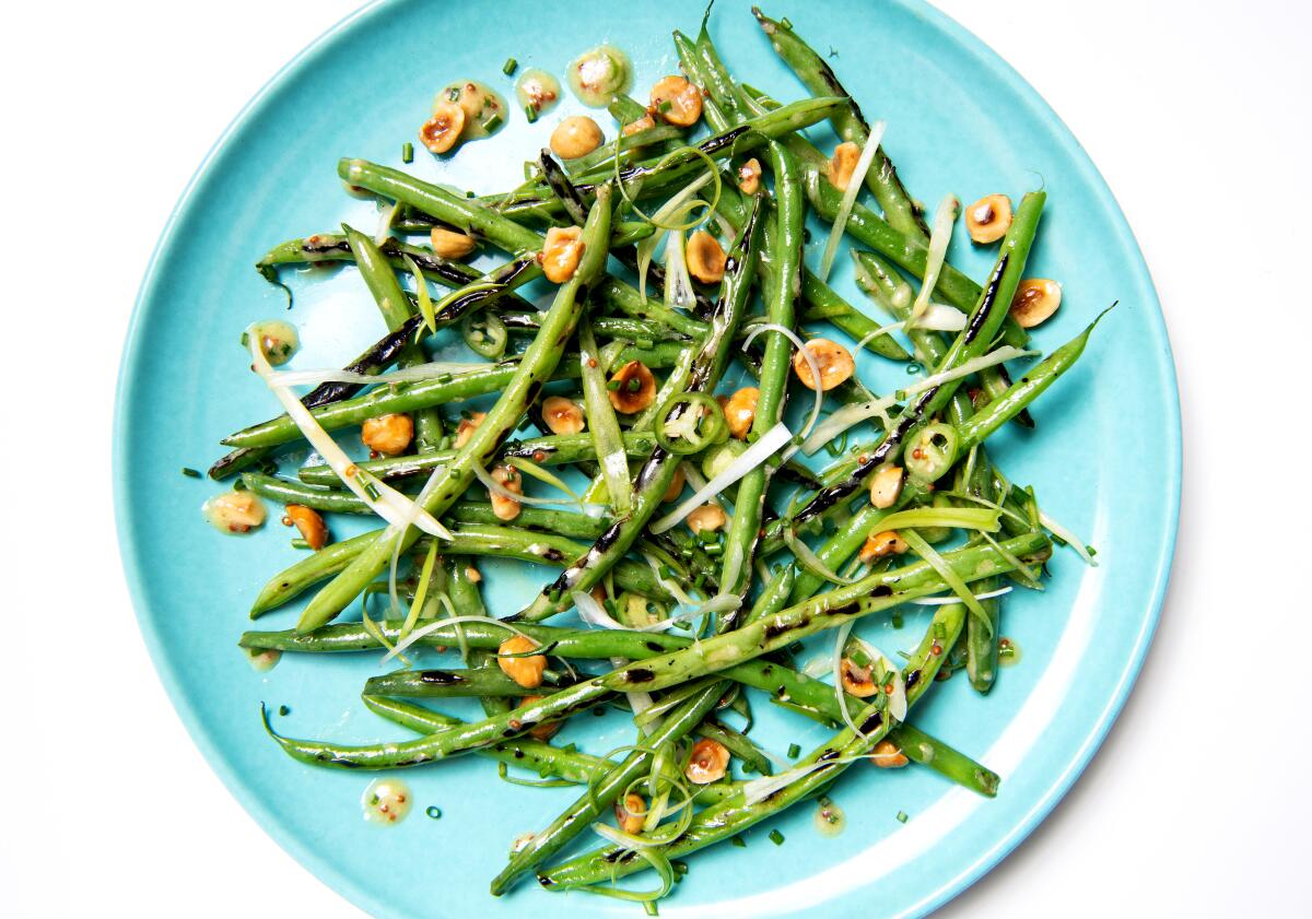 A plate of charred green beans with hazelnuts, scallions and serrano chiles.