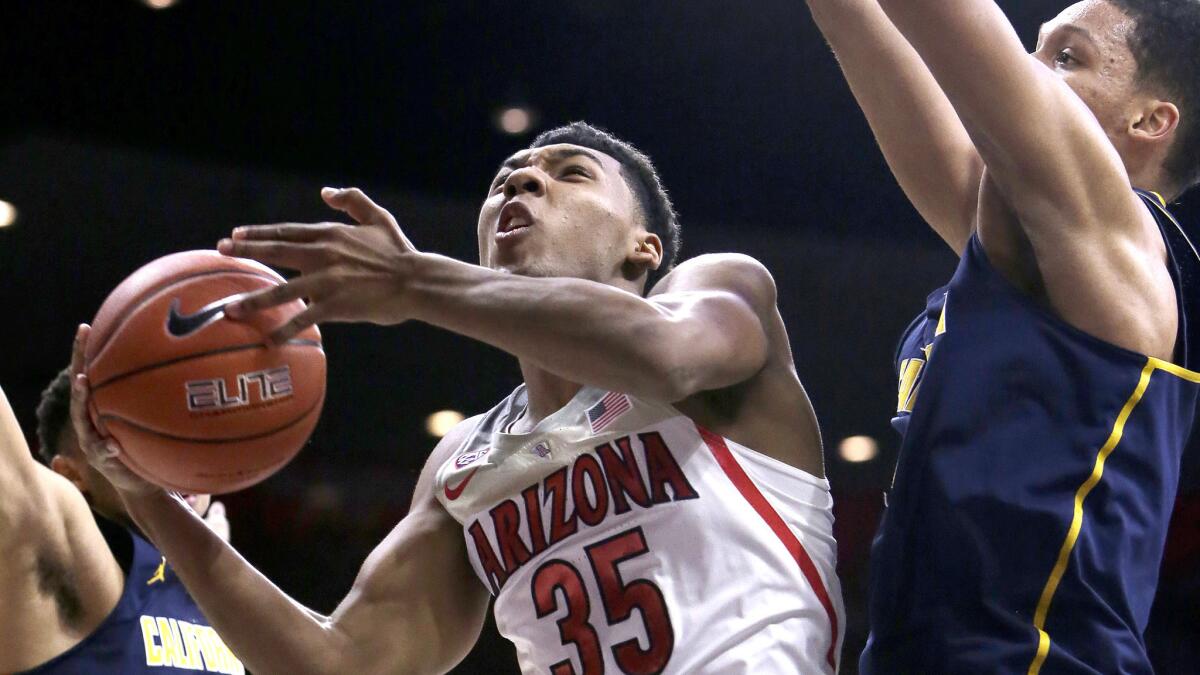 Arizona guard Allonzo Trier (35) drives between California's Stephen Domingo (31) and Ivan Rabb (1) for a layup during the second half Saturday.