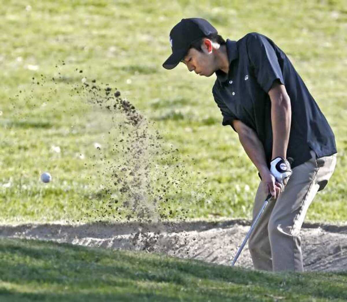 Crescenta Valley High School's Paul Park chips out of the sand trap during play in the 48th Annual Burbank High Schools Invitational at DeBell Golf Club in March.