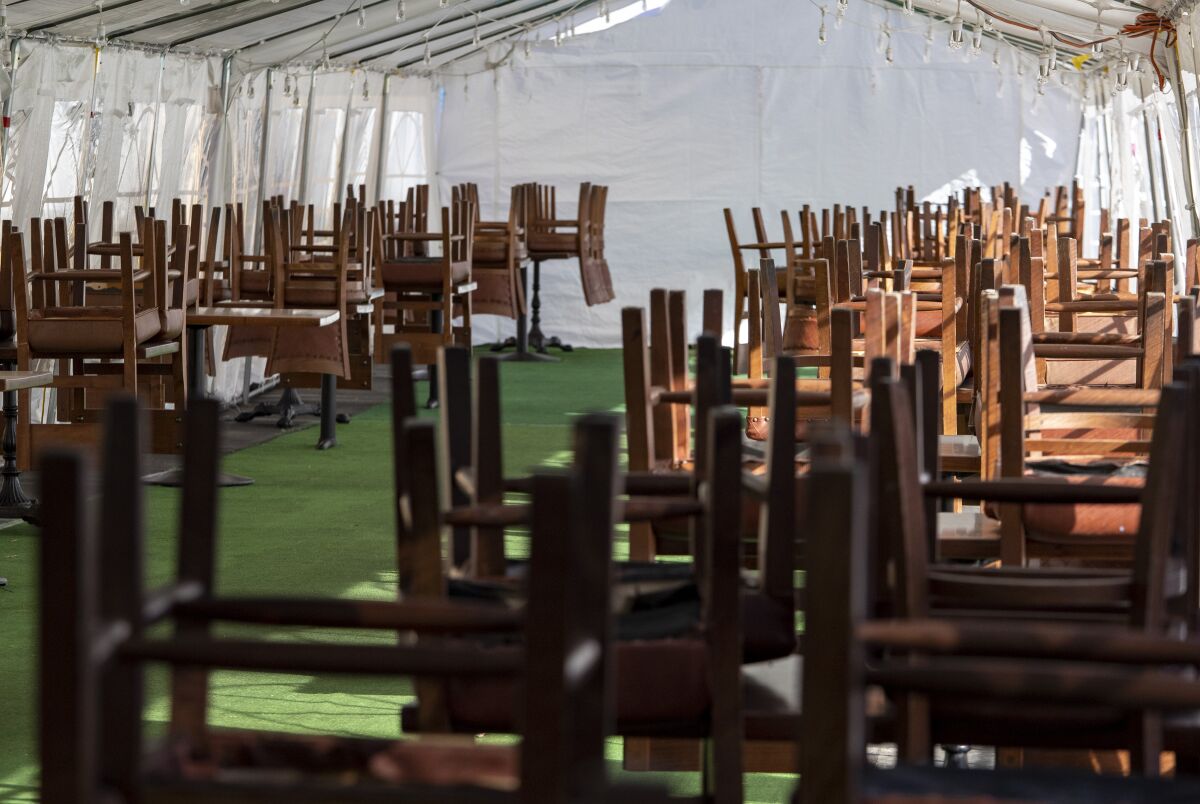Chairs are stacked atop tables in a dining tent.