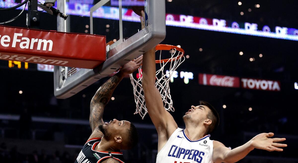 Clippers center Ivica Zubac blocks a shot by Portland Trail Blazers guard Damian Lillard during a March 12 game at Staples Center.
