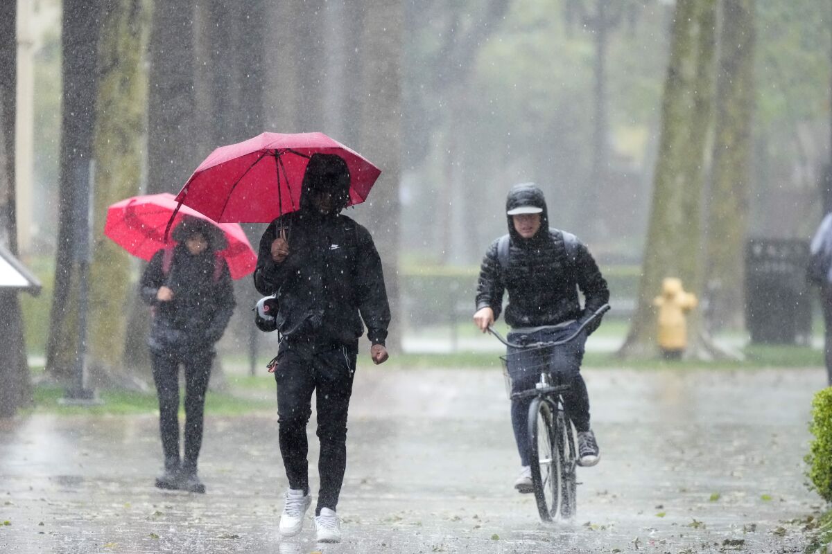 Rain falls on pedestrians on the University of Southern California campus on Tuesday, March 21, 2023, in Los Angeles. (AP Photo/Marcio Jose Sanchez)