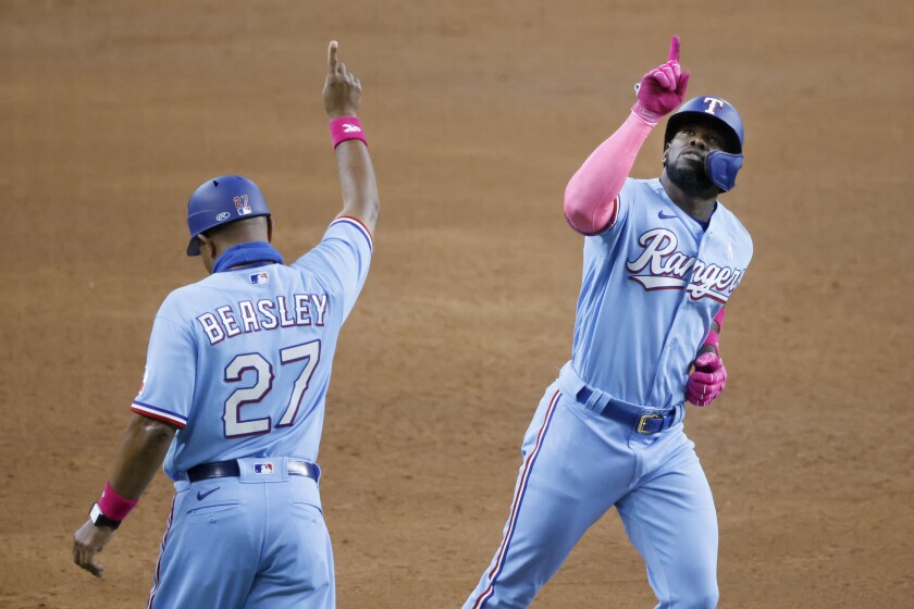 Texas Rangers center fielder Adolis Garcia (53) celebrates his three-home run against the Seattle Mariners with third base coach Tony Beasley (27) during the fifth inning of a baseball game Sunday, May 9, 2021, in Arlington, Texas. (AP Photo/Michael Ainsworth)