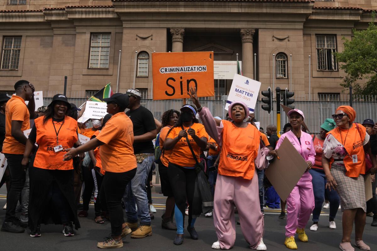 South African women's rights groups and sex workers demonstrate outside the magistrate court in Johannesburg, South Africa, Tuesday, Oct. 18, 2022, where a 21-year-old man appeared in connection with the discovery of six decomposed bodies believed to be those of sex workers. (AP Photo/Themba Hadebe)