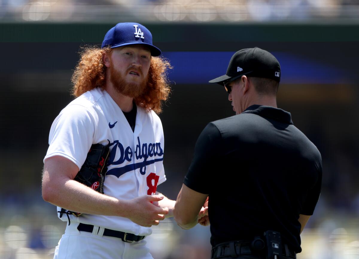 Dodgers starting pitcher Dustin May has his hands checked by umpire Shane Livensparger.
