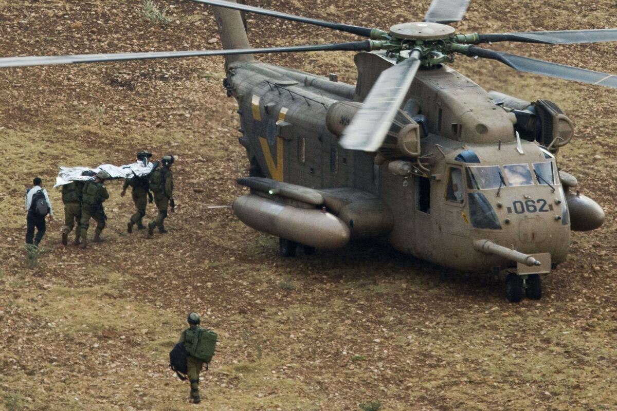 Israeli troops carry the body of a fellow soldier killed in the West Bank to a waiting helicopter.