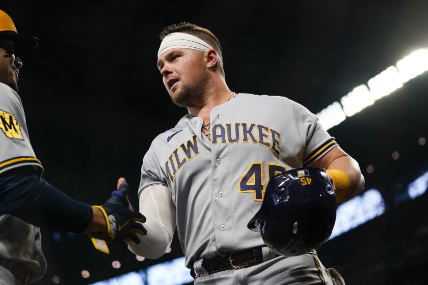 FILE - Milwaukee Brewers' Luke Voit is greeted by a teammate after scoring during the second inning of a baseball game against the Seattle Mariners, April 17, 2023, in Seattle. The Milwaukee Brewers have designated first baseman Voit for assignment on Monday, May 29, 2023. The 32-year-old Voit could not provide the Brewers the type of power had had produced for much of his career. (AP Photo/Lindsey Wasson, File)