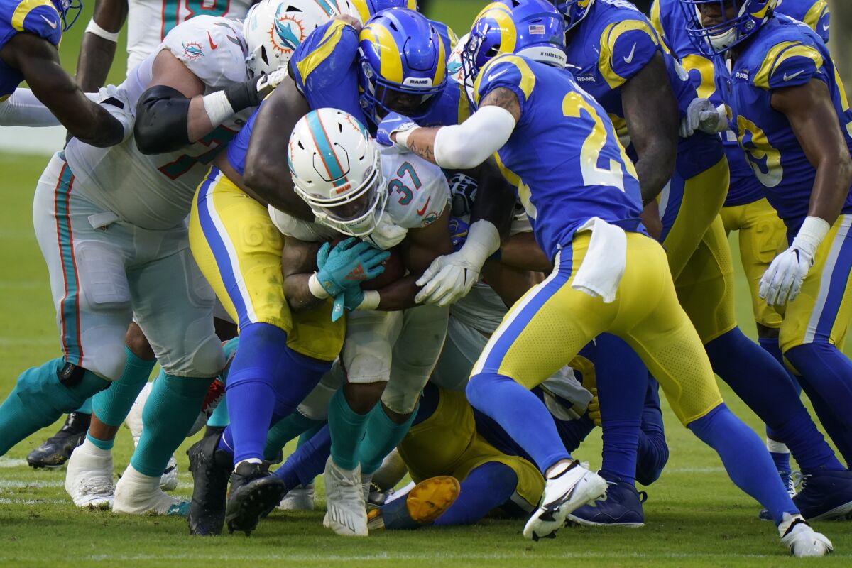Dolphins running back Myles Gaskin is tackled by Rams safety Taylor Rapp.