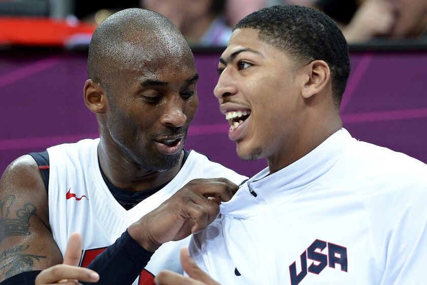 Lakers star Kobe Bryant, left, and New Orleans Pelicans forward Anthony Davis talk while sitting on the bench during a game at the 2012 London Olympics.