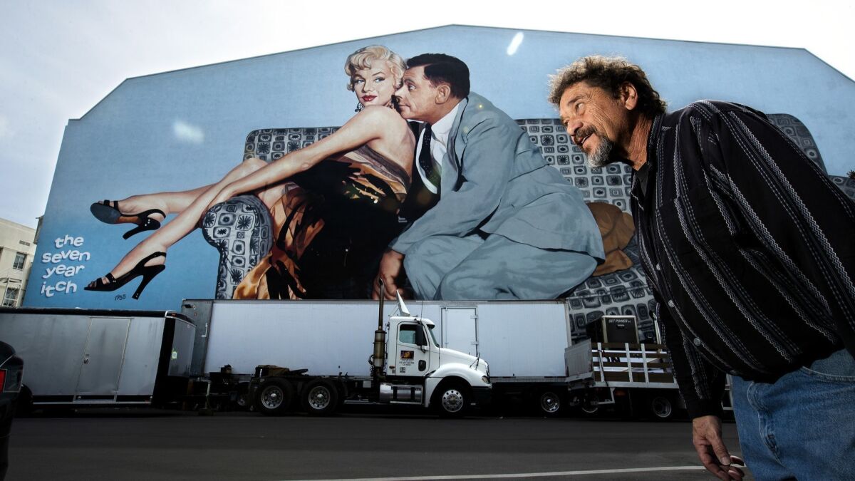 Scenic painter Mike Denering in front of a mural, a scene from "The Seven Year Itch" that he restored back in 2016 with artist Jim Katranis on the exterior of Stage 10 at Fox Studios in Los Angeles.