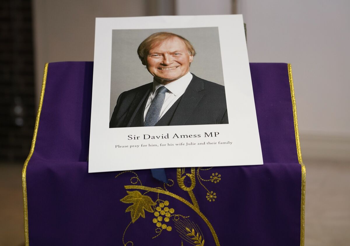 An image of murdered British Conservative lawmaker David Amess is displayed near the altar in St Peters Catholic Church before a vigil in Leigh-on-Sea, Essex, England, Friday, Oct. 15, 2021. Amess died after being stabbed earlier Friday during a meeting with constituents at another nearby church in eastern England. Police gave no immediate details on the motive for the killing of 69-year-old Conservative lawmaker Amess and did not identify the suspect, who was being held on suspicion of murder. (AP Photo/Alberto Pezzali)