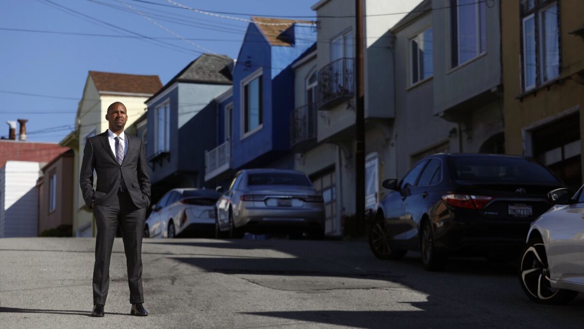 San Francisco Supervisor Shamann Walton pauses on Topeka Avenue in the city's Bayview district, near the former home of his great-aunt. Since the tech-fueled real estate boom, Walton's family has scattered to Sacramento and the far East Bay communities of Vallejo and Antioch.