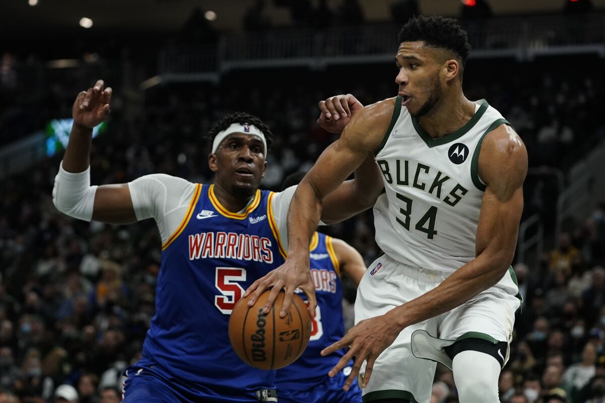 Milwaukee Bucks' Giannis Antetokounmpo drives past Golden State Warriors' Kevon Looney during the second half of an NBA basketball game Thursday, Jan. 13, 2022, in Milwaukee. (AP Photo/Morry Gash)