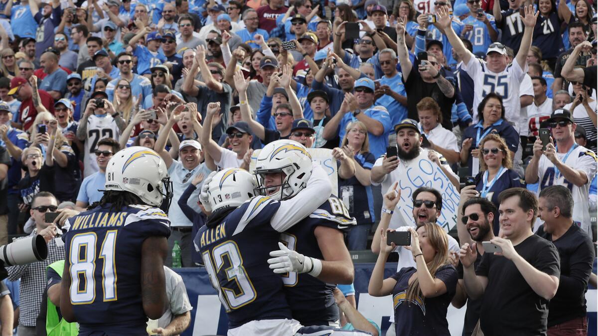Chargers tight end Hunter Henry celebrates catching a touchdown pass with teammates Keenan Allen and Mike Williams and hundreds of fans during first half action against the Redskins at Stubhub Center.