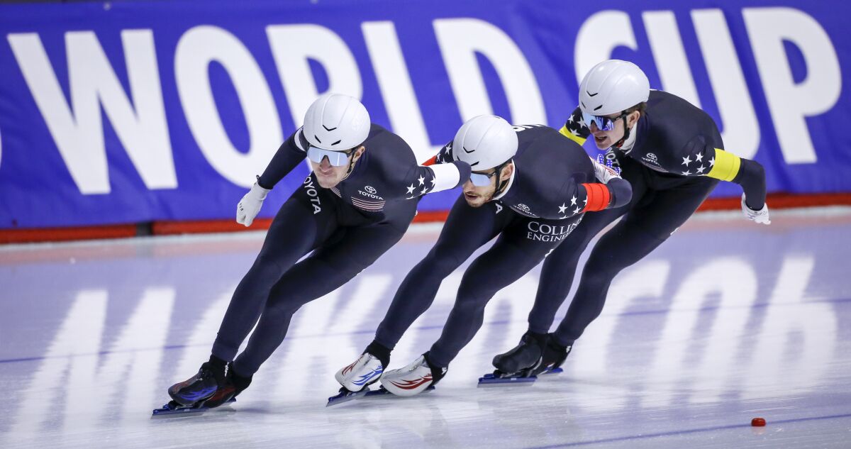 Casey Dawson, left, of the United States, leads teammates Emery Lehman, center, and Ethan Cepuran during the men's team pursuit competition at the ISU World Cup speedskating event in Calgary, Alberta, Sunday, Dec. 12, 2021. (Jeff McIntosh/The Canadian Press via AP)