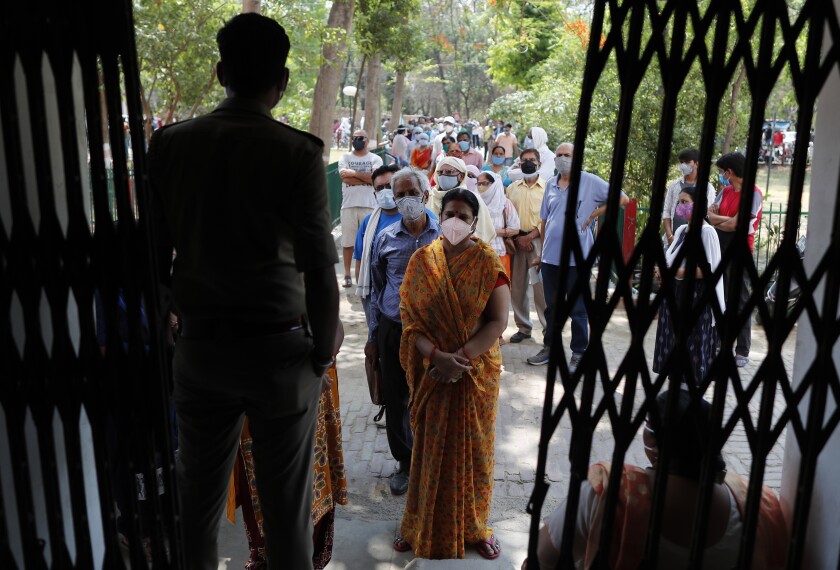Indians line up to receive the vaccine for COVID-19 at a medical college in Prayagraj, India, Saturday, May 8, 2021. Two southern states in India became the latest to declare lockdowns, as coronavirus cases surge at breakneck speed across the country and pressure mounts on Prime Minister Narendra Modi's government to implement a nationwide shutdown. (AP Photo/Rajesh Kumar Singh)