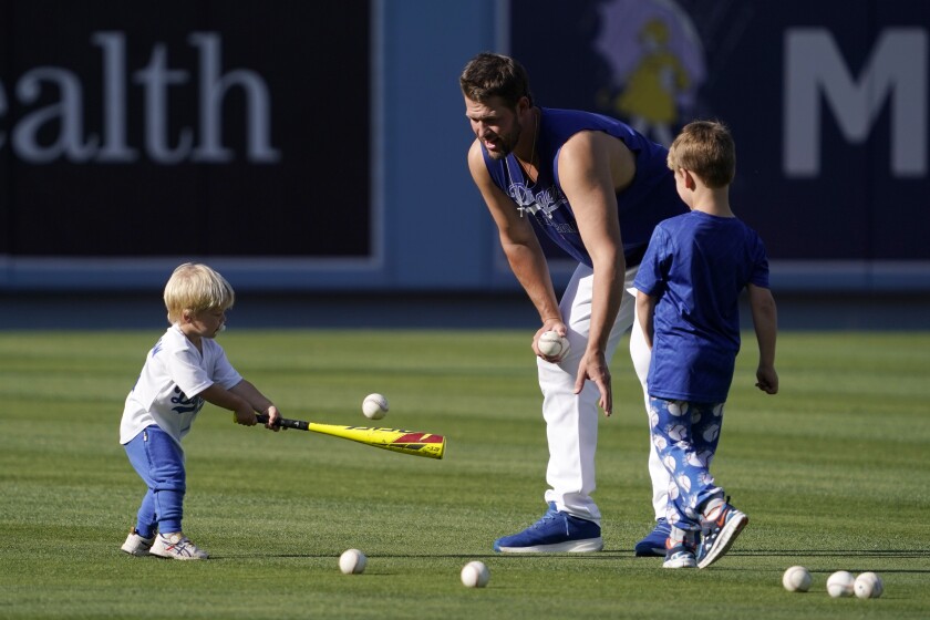 Clayton Kershaw pitches to his son Cooper, as son Charley watches before Tuesday's game.
