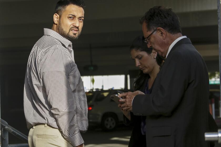 Syed Raheel Farook, left, is released on bail at the Riverside Federal Courthouse in April 2016. He and wife, Tatiana Farook, have pleaded guilty to charges of conspiracy to commit immigration fraud related to a sham marriage.