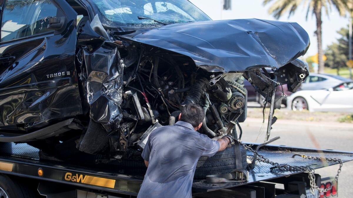 Fausto Bigueras prepares to haul away a Chevrolet Tahoe that police said struck a vehicle and crashed into the patio of The Bungalow Restaurant in Corona del Mar on Tuesday morning.