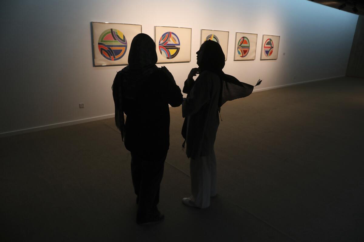 Silhouettes of two women at art exhibit