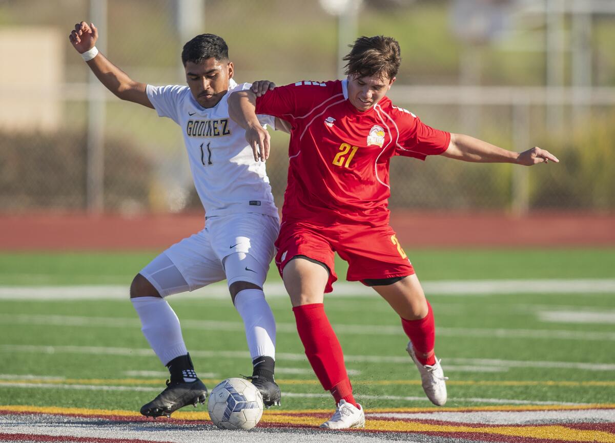 Godinez's Ivan Lopez (11) and Ocean View's Ethan Hilario (21) battle for a ball during a Golden West League match on Wednesday.