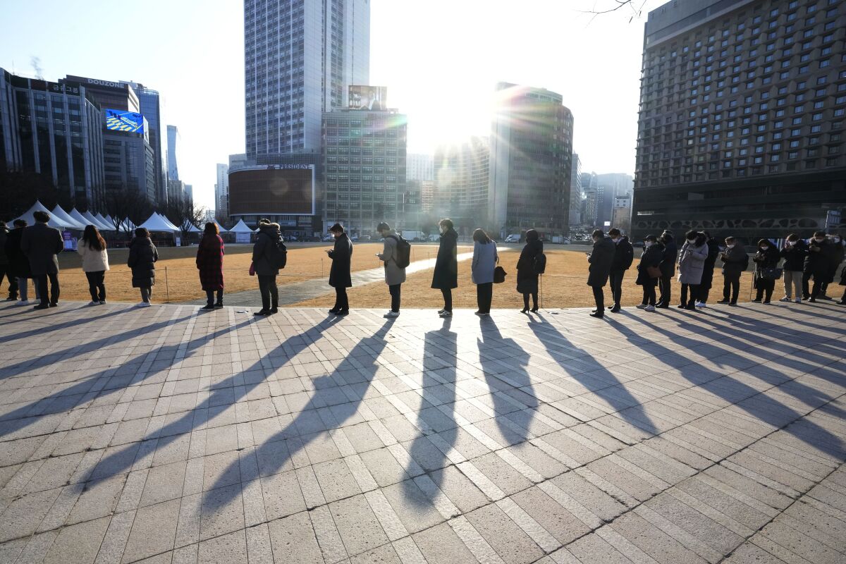 People wait for their coronavirus test at a makeshift testing site in Seoul, South Korea, Wednesday, Feb. 16, 2022. (AP Photo/Ahn Young-joon)