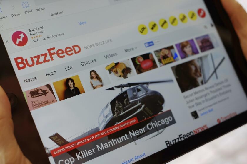 FILE- In this Sept. 2, 2015, file photo the BuzzFeed website is displayed on an iPad held by an Associated Press staffer in Los Angeles. Media company BuzzFeed is cutting 15 percent of its jobs, or about 200 people, to trim costs and become profitable. BuzzFeed CEO Jonah Peretti said in a memo to employees Wednesday, Jan. 23, 2019, that the layoffs will help BuzzFeed avoid having to raise money from investors again. (AP Photo/Richard Vogel, File)