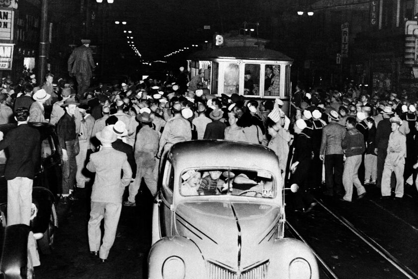 Soldiers, sailors and marines who roamed the street of Los Angeles, June 7, 1943, looking for hoodlums in zoot suits, stopped this streetcar during their search. Crowds jammed downtown streets to watch the service men tear clothing off the zoot suiters they caught. (AP Photo)