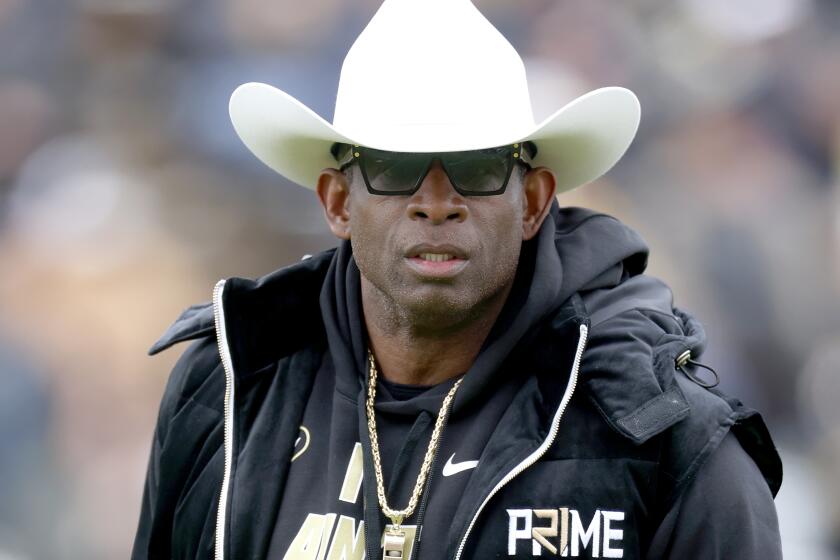 Colorado coach Deion Sanders watches as his team warms before playing their spring game