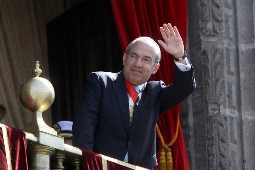 Mexican President Felipe Calderon waves from the presidential palace. He hands over his post Saturday to Enrique Peña Nieto.