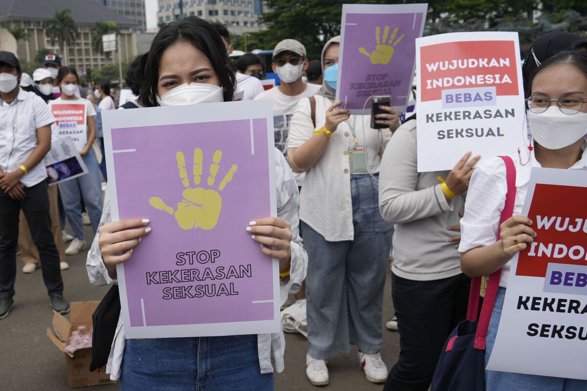 Activists hold posters reading "Stop sexual violence" and "Free Indonesia from sexual violence" during a rally.