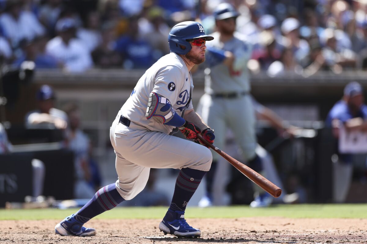 Max Muncy watches his two-run single against the San Diego Padres.