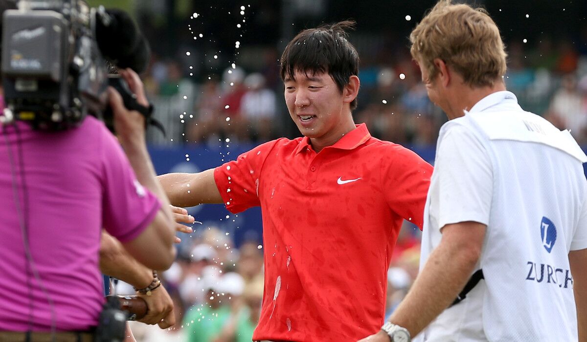 Seung-Yul Noh celebrates with fellow golfers Charlie Wi and Y.E. Yang (not pictured) and his caddie Scott Saitinac after winning the Zurich Classic on Sunday at TPC Louisiana.