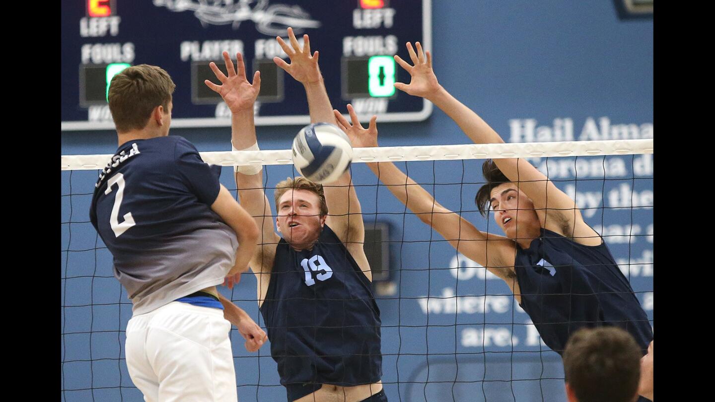 Corona del Mar High blockers Brandon Hicks (19) and Brandon Browning (1) block the kill attempt by Loyola High's Jaxon Drake during boys’ volleyball semifinal CIF Southern Section Division 1 playoffs on Wednesday.