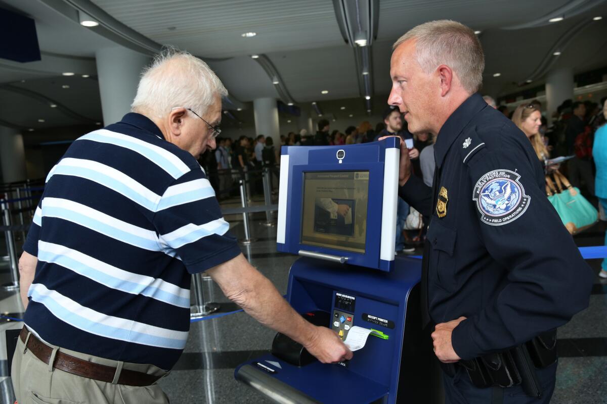 A traveler returning to the U.S. gets help using a kiosk to file his customs declaration at Chicago O'Hare International Airport. Soon international fliers will be able to file their re-entry documents on their mobile devices.