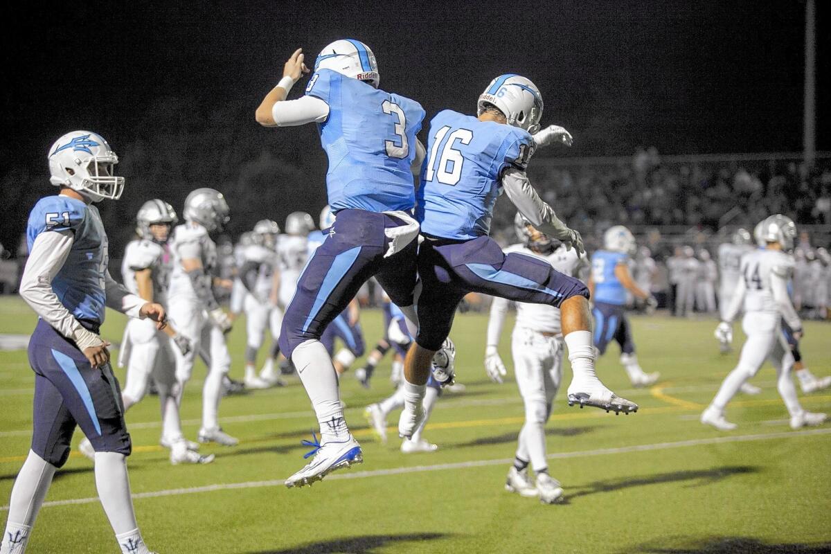 Corona del Mar High quarterback Chase Garbers (3) celebrates with Reece Perez after Perez scores a touchdown in the final seconds of the first half during a CIF Southern Section Southwest Division first-round playoff game against Trabuco Hills on Friday.