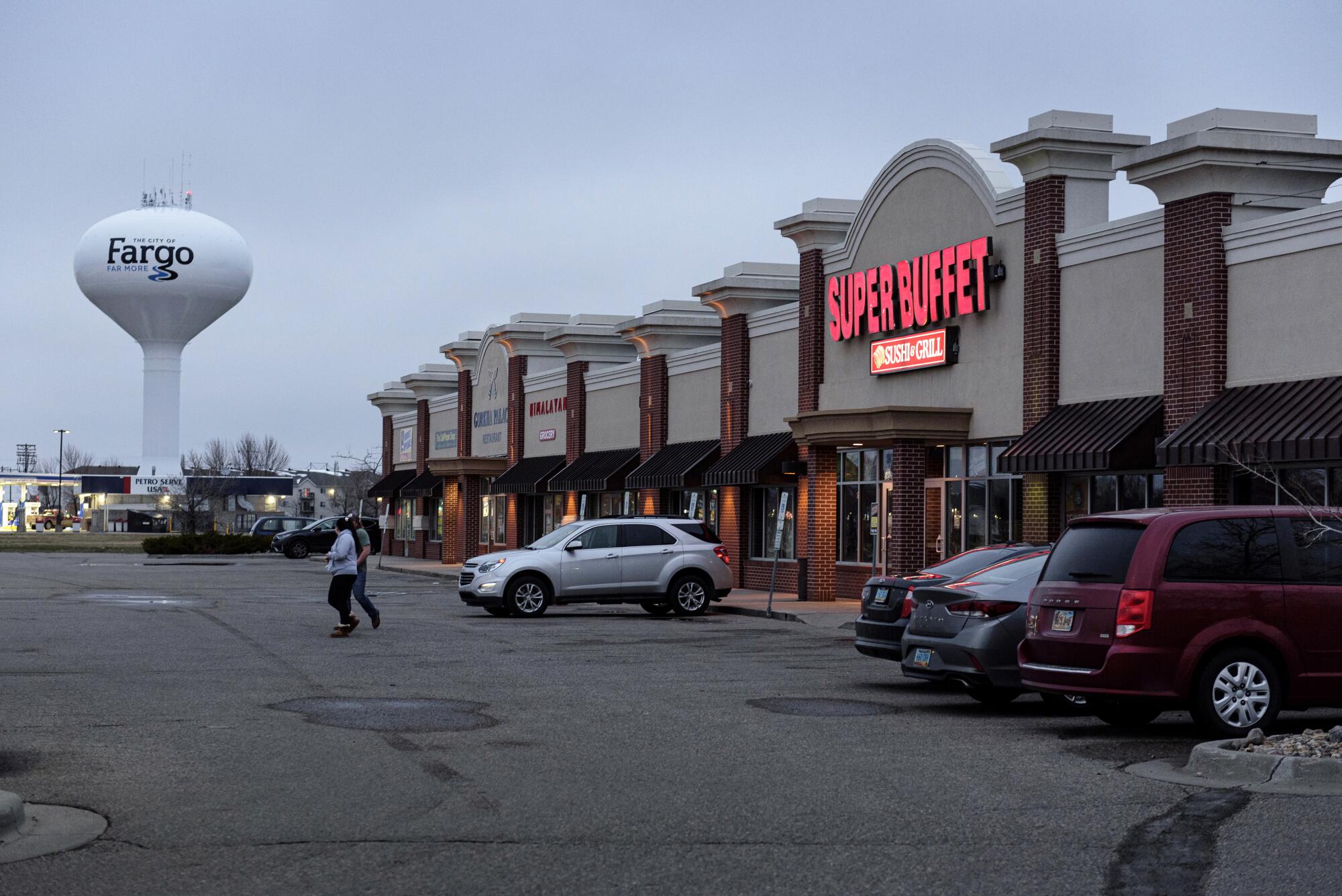 A water tower labeled Fargo is in the background of a strip mall with a restaurant called Super Buffet