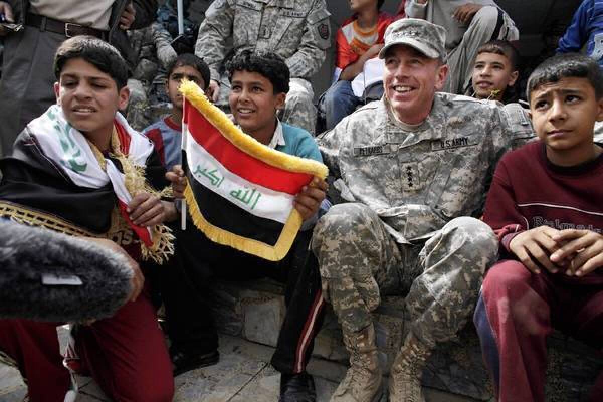 Gen. David Petraeus sits with Iraqi children during a youth soccer tournament in central Baghdad on March 1, 2008.