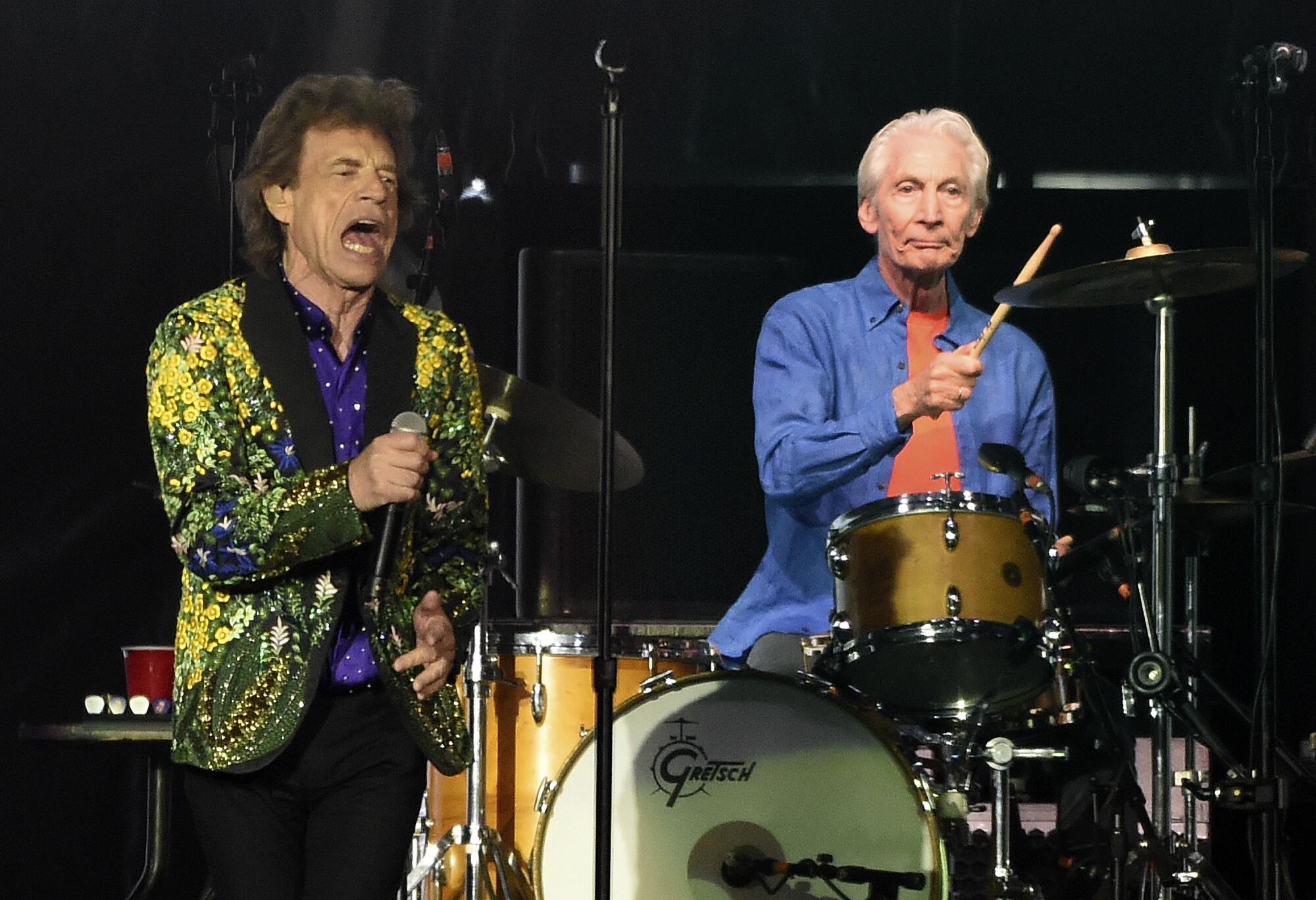 Rolling Stones drummer Charlie Watts, right, performs behind singer Mick Jagger.